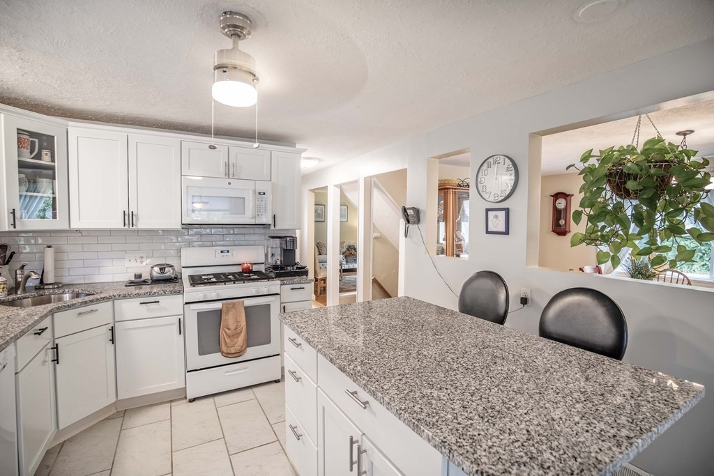 96 Wyman Road Billerica, MA 01821 - Photo 11 of 35 a kitchen with stainless steel appliances granite countertop a stove a sink and a refrigerator