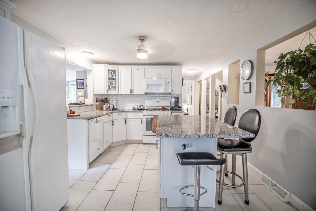 96 Wyman Road Billerica, MA 01821 - Photo 12 of 35 a kitchen with cabinets and chairs
