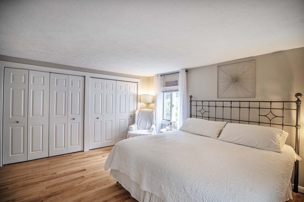 96 Wyman Road Billerica, MA 01821 - Photo 27 of 35 a bedroom with a large bed and wooden floor