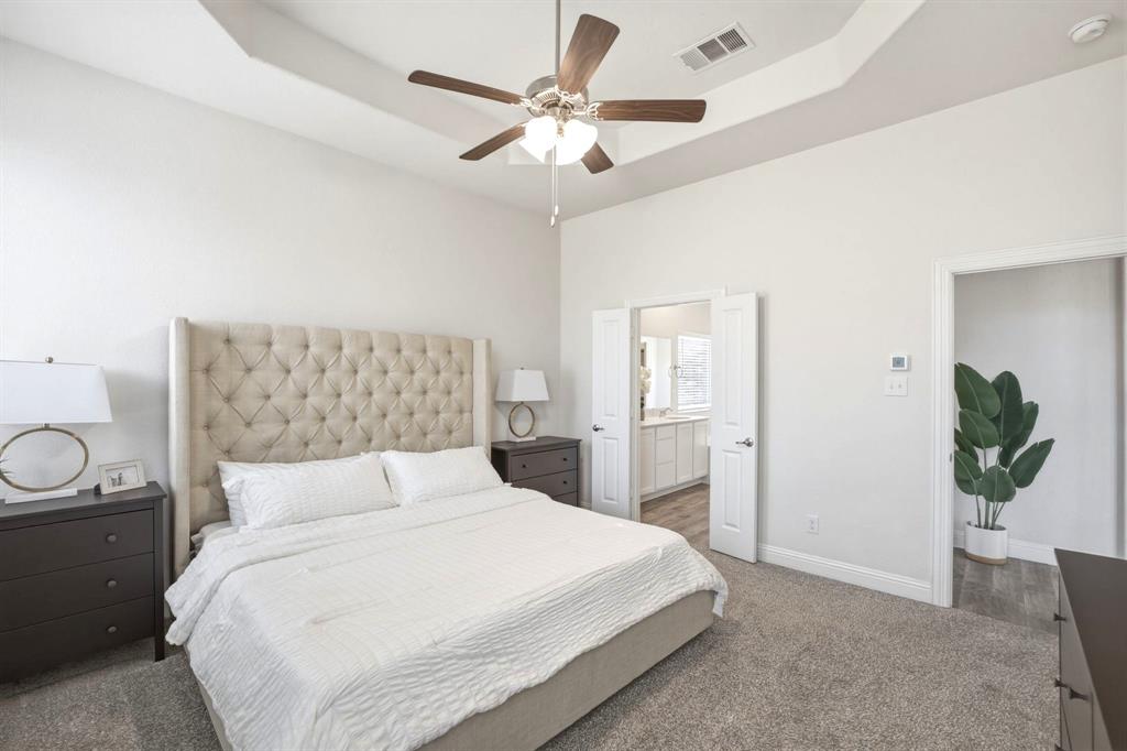 2909 Faro Road Aubrey, TX 76227 - Photo 13 of 32 a bedroom with a bed and a chandelier