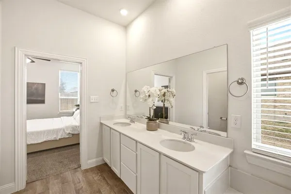 a en suite bathroom with a double vanity sink and a mirror
