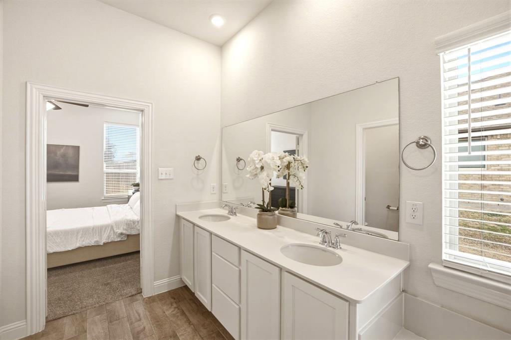 2909 Faro Road Aubrey, TX 76227 - Photo 15 of 32 a en suite bathroom with a double vanity sink and a mirror