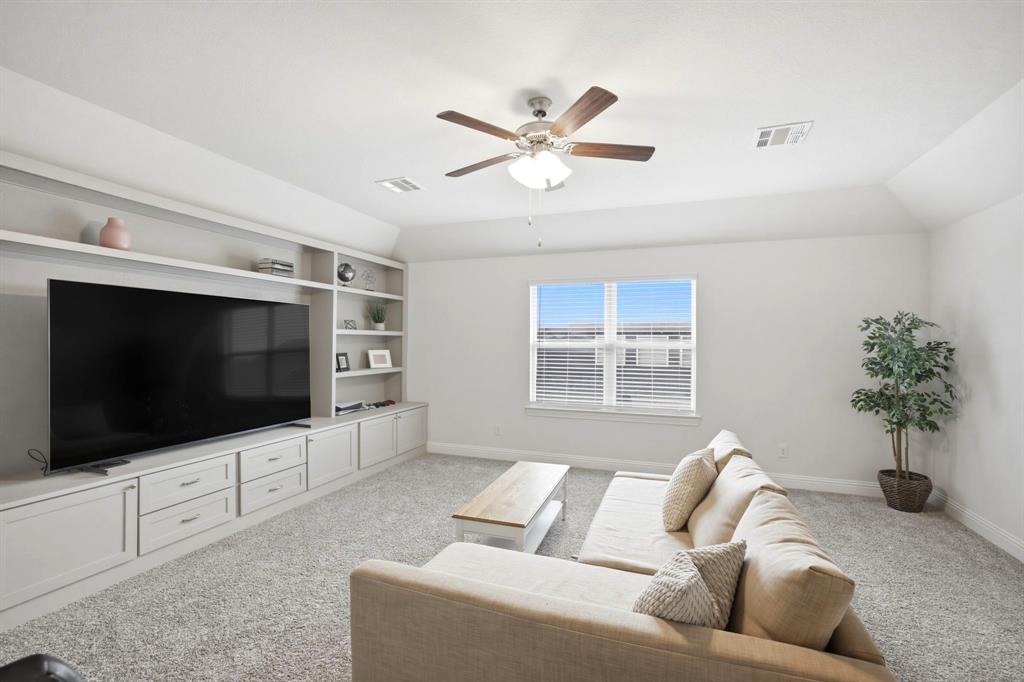 2909 Faro Road Aubrey, TX 76227 - Photo 20 of 32 a living room with furniture and a flat screen tv