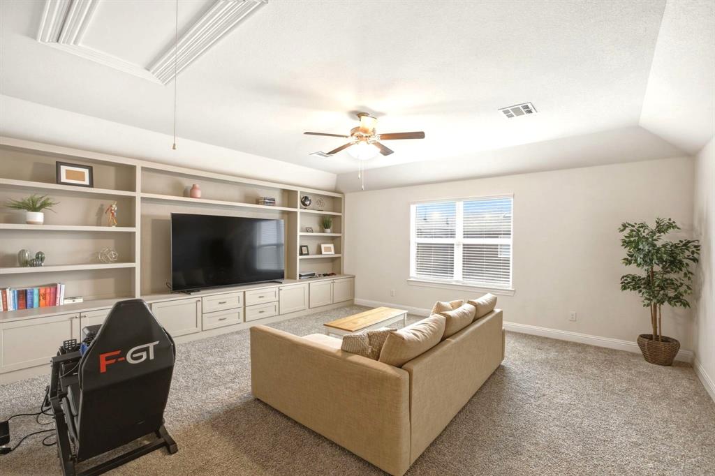 2909 Faro Road Aubrey, TX 76227 - Photo 21 of 32 a living room with furniture and a flat screen tv