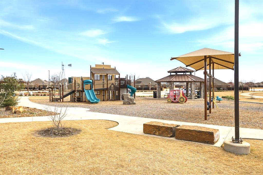 2909 Faro Road Aubrey, TX 76227 - Photo 28 of 32 a view of a swimming pool with a lawn chairs under an umbrella
