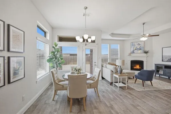 a dining room with furniture a chandelier and wooden floor