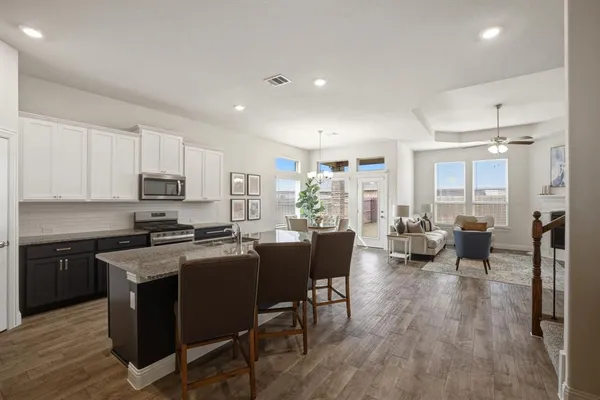 a kitchen with sink a refrigerator and chairs