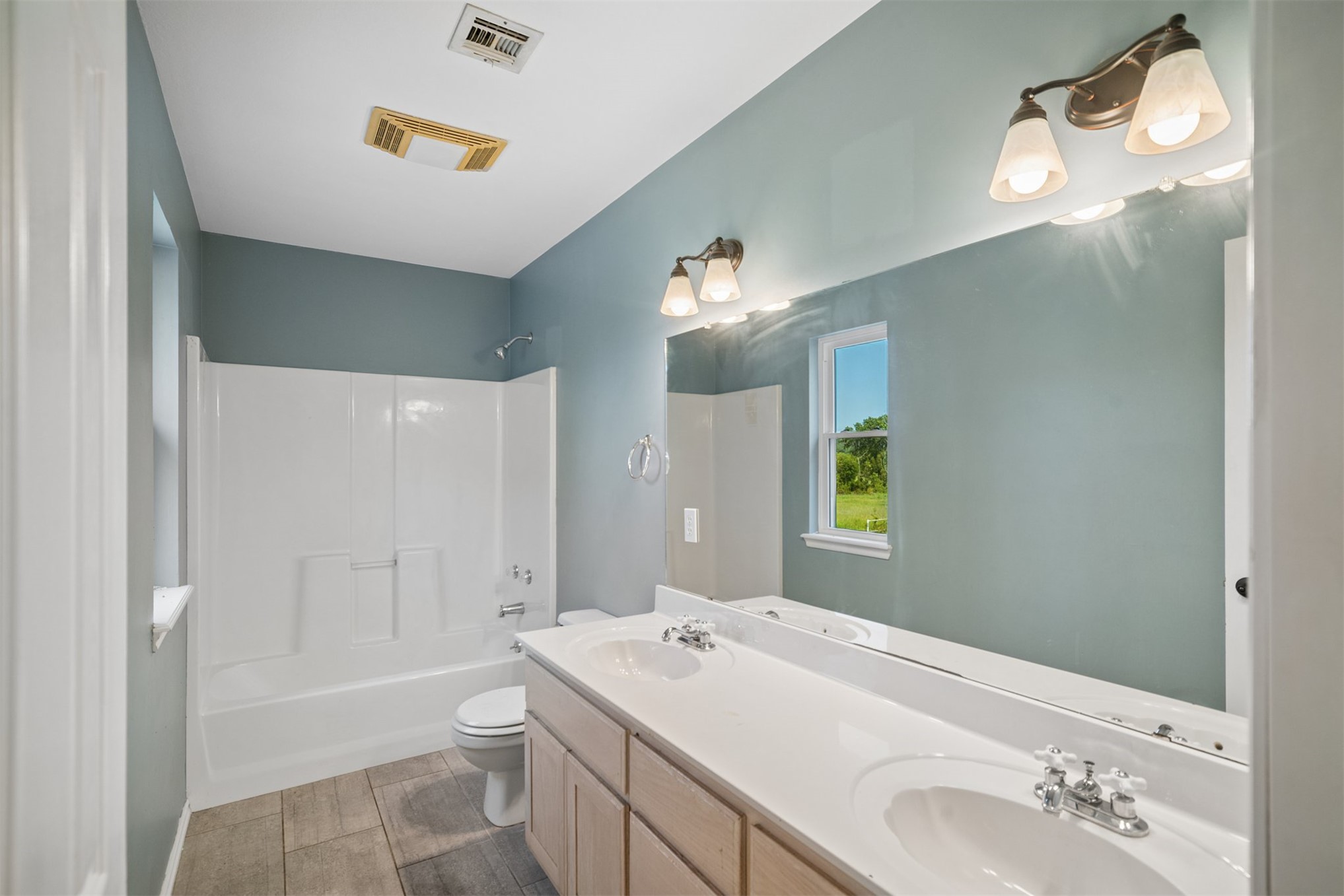 175 Alt 75 Mounds, OK 74047 - Photo 33 of 41 Double vanity with integrated sinks, full-width mirror, and a shower-tub combination