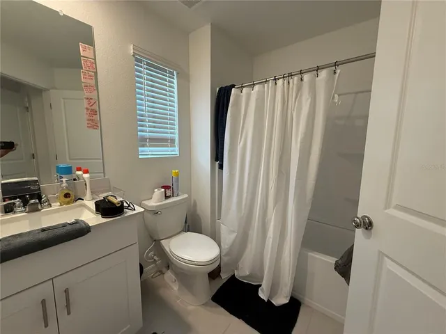 a spacious bathroom with double vanity sink a mirror and a toilet