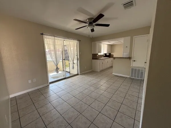 a large white kitchen with a large window a sink and stainless steel appliances