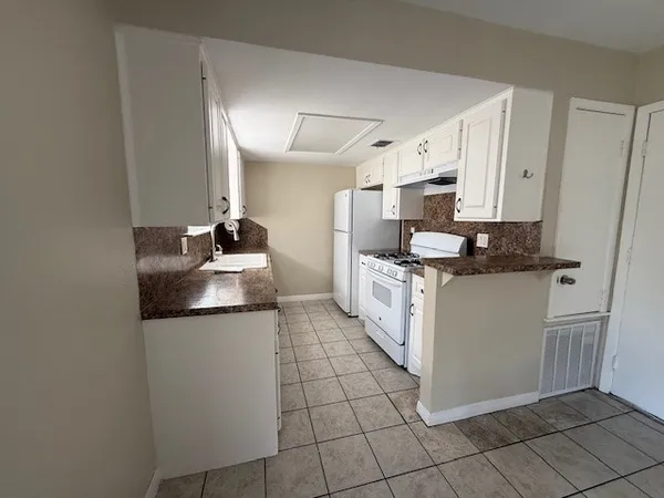 a kitchen with stainless steel appliances granite countertop a sink and a stove top oven
