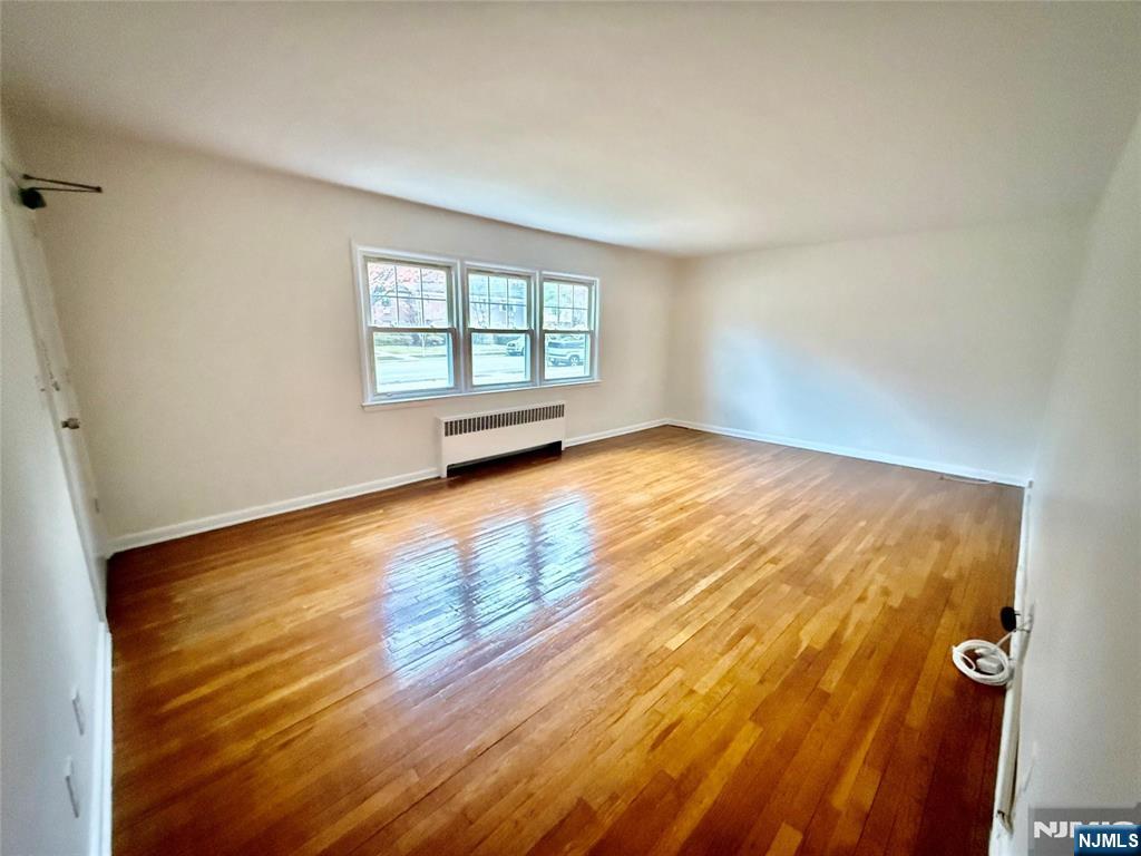 293 Bogert Road River Edge, NJ 07661 - Photo 6 of 14 a view of an empty room with wooden floor and a window