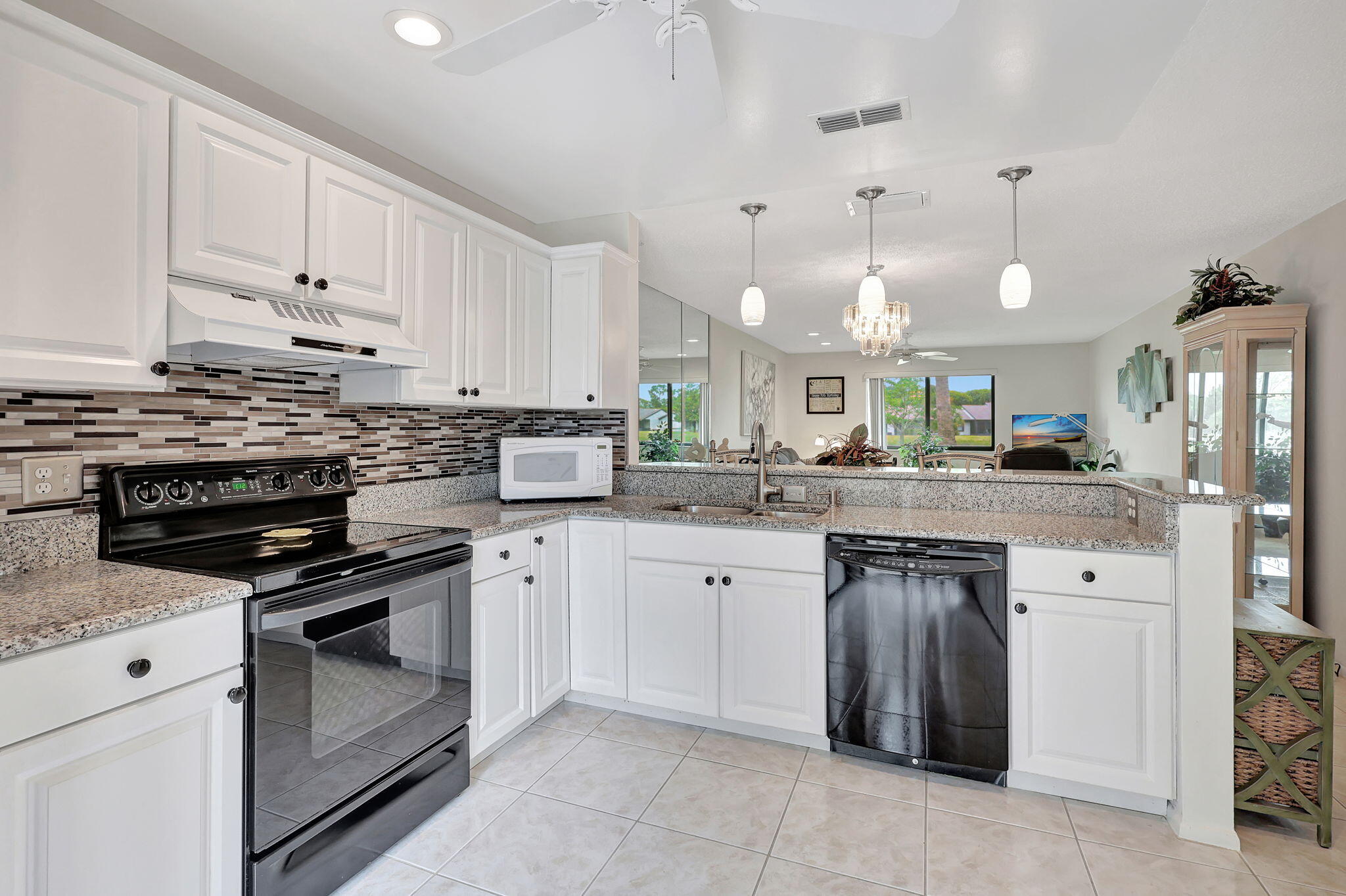 a kitchen with kitchen island granite countertop a stove a sink dishwasher and a refrigerator with wooden floor