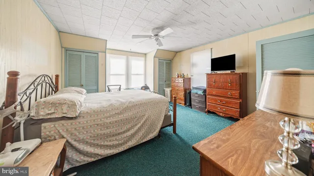 a bedroom with a bed and a flat tv screen on dresser