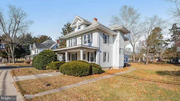a front view of a house with a yard and trees