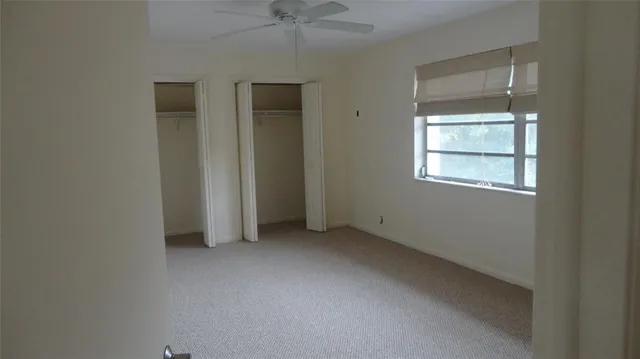 an empty room with windows and closet