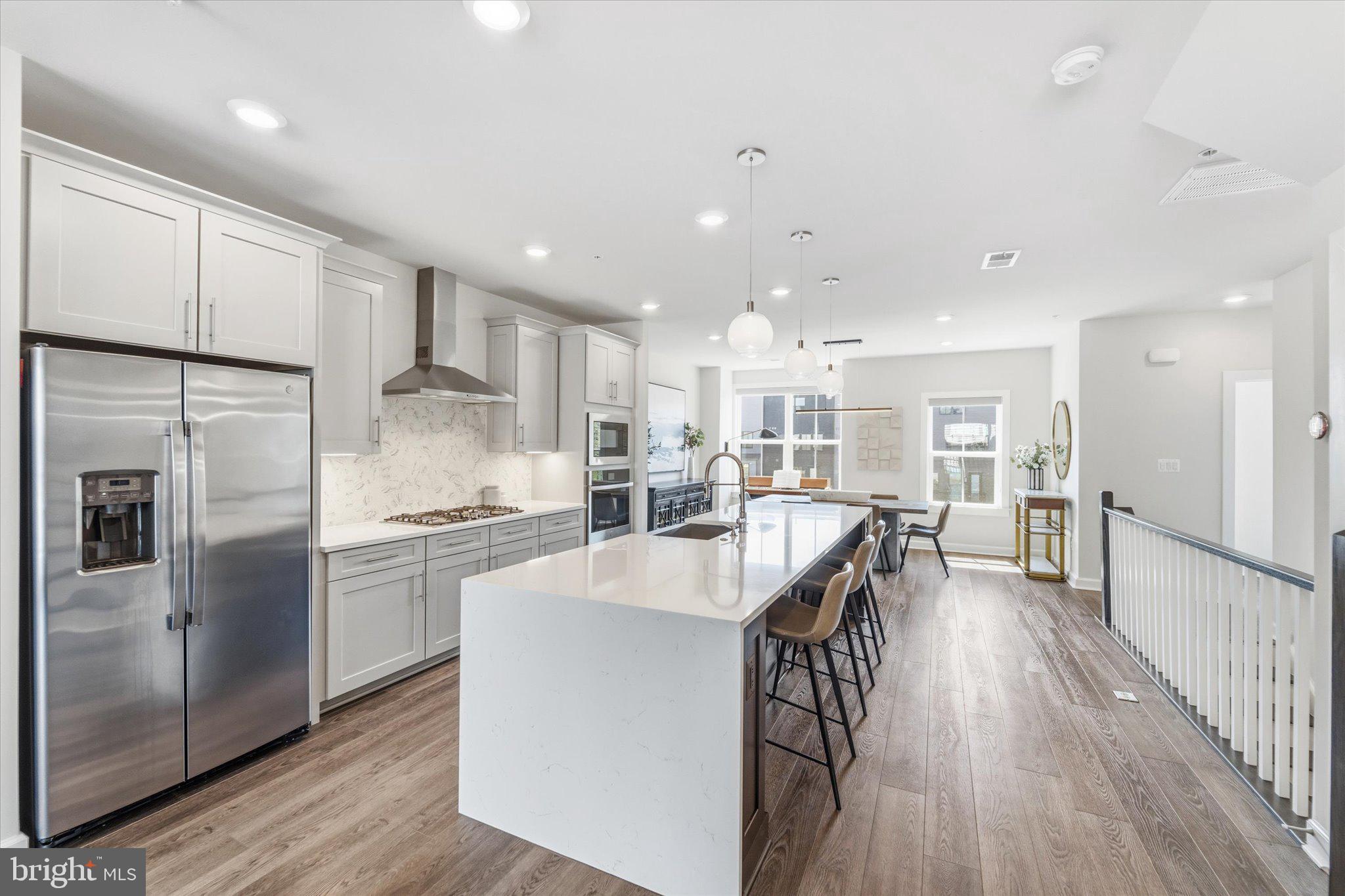 12915 Sunrise Ridge Alley, Unit 74 Herndon, VA 20171 - Photo 11 of 48 a large kitchen with kitchen island a large counter top space a sink stainless steel appliances and cabinets