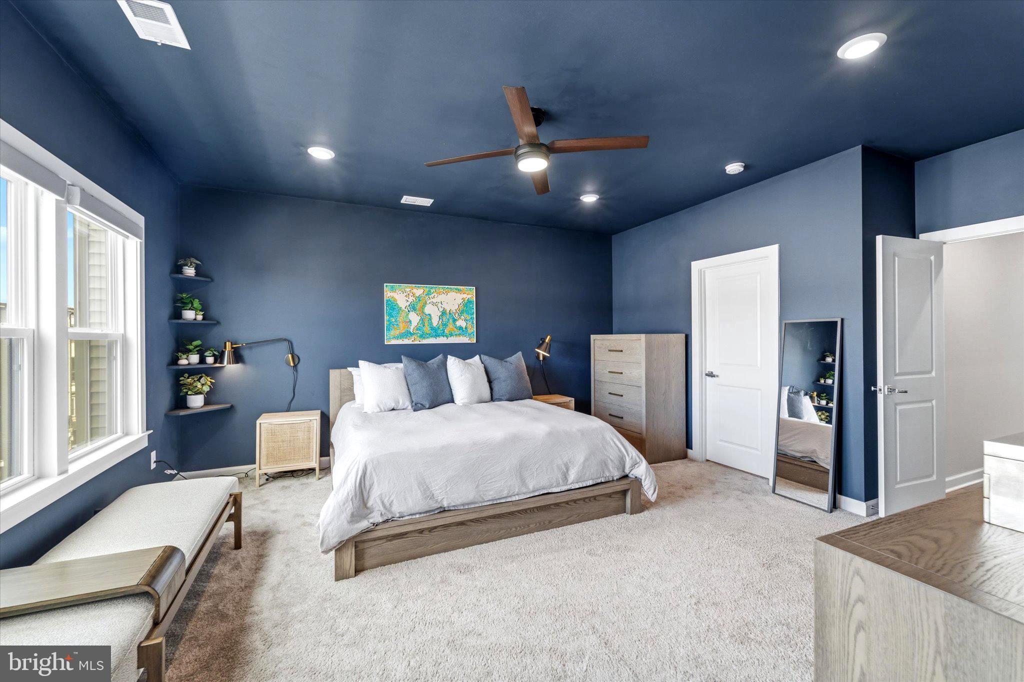 12915 Sunrise Ridge Alley, Unit 74 Herndon, VA 20171 - Photo 5 of 48 a spacious bedroom with a large bed and a chandelier