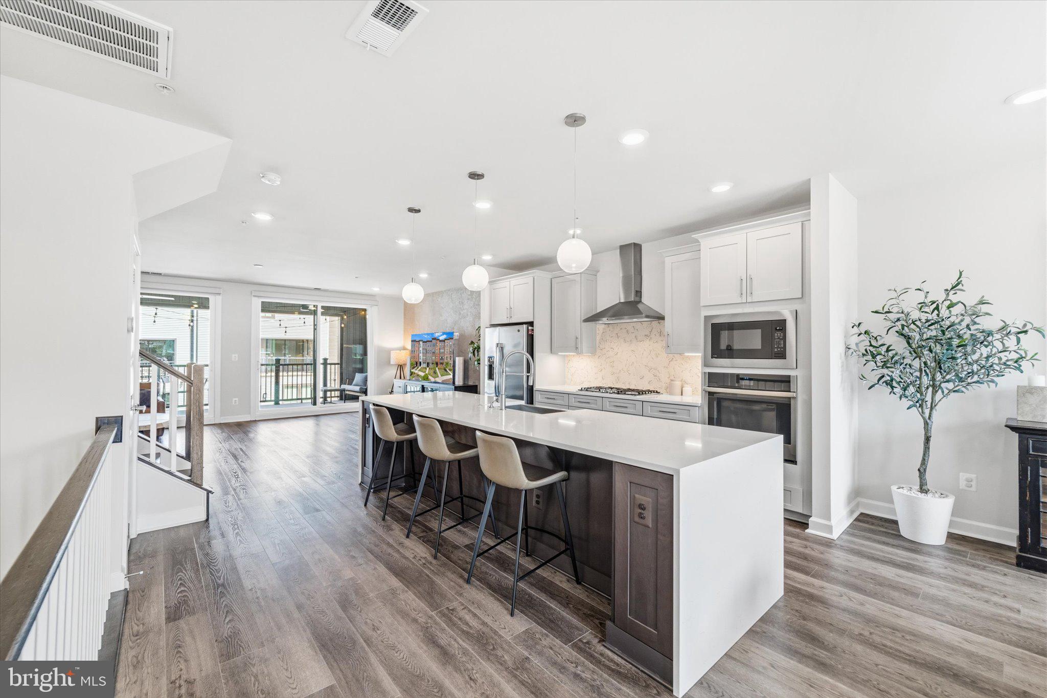 12915 Sunrise Ridge Alley, Unit 74 Herndon, VA 20171 - Photo 9 of 48 a large kitchen with kitchen island a sink a center island and a wooden floor