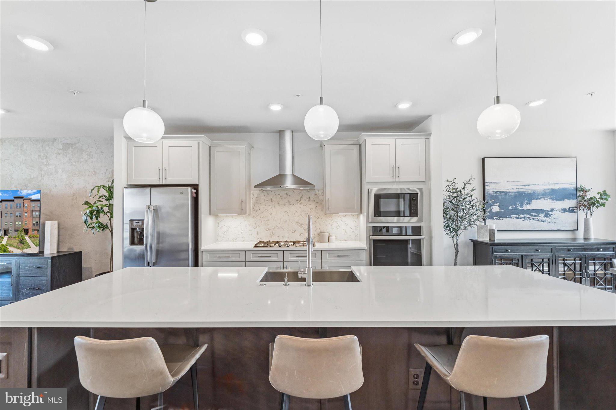 12915 Sunrise Ridge Alley, Unit 74 Herndon, VA 20171 - Photo 10 of 48 a kitchen with stainless steel appliances granite countertop a kitchen island a stove a table and chairs