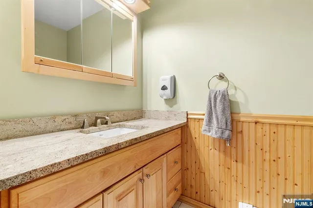 a bathroom with a granite countertop sink and a mirror