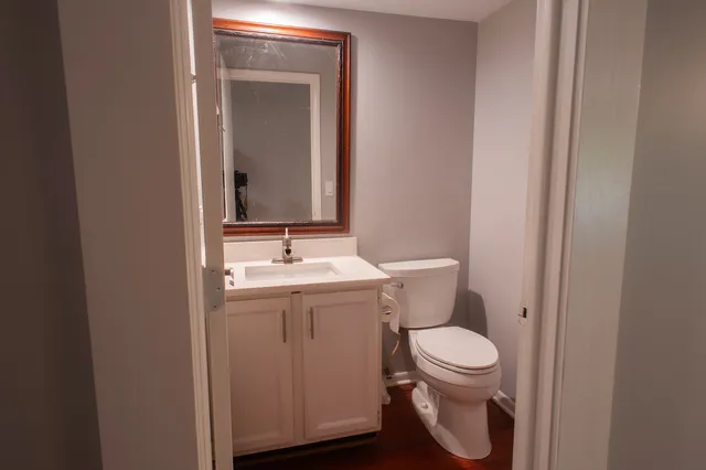 a bathroom with a toilet sink and mirror
