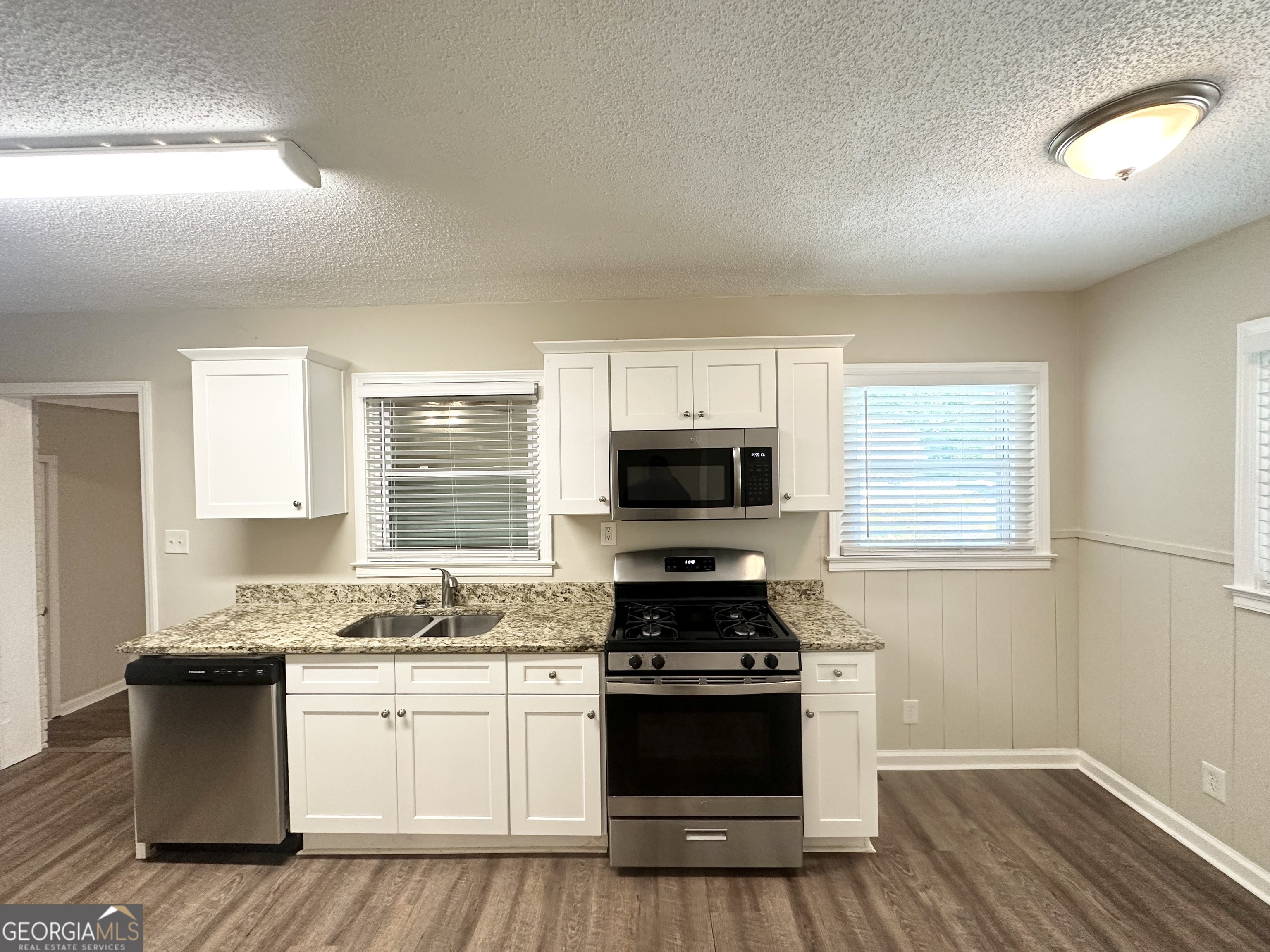 1089 Canal Street Decatur, GA 30032 - Photo 5 of 18 a kitchen with granite countertop a stove top oven a sink dishwasher a dining table and chairs with wooden floor