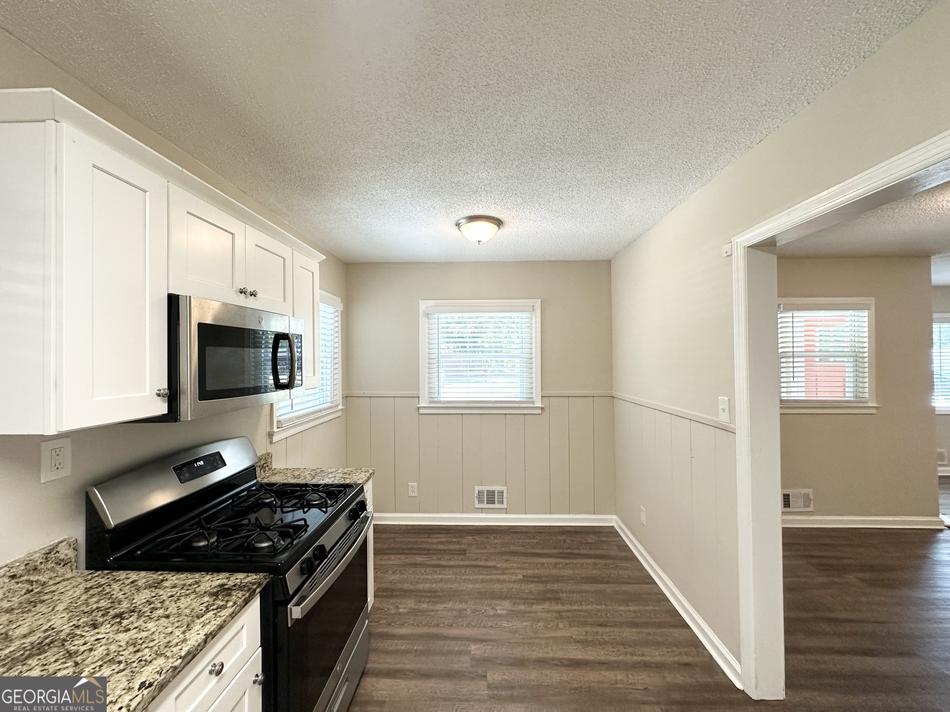 1089 Canal Street Decatur, GA 30032 - Photo 7 of 18 a kitchen with granite countertop a stove and a wooden floor