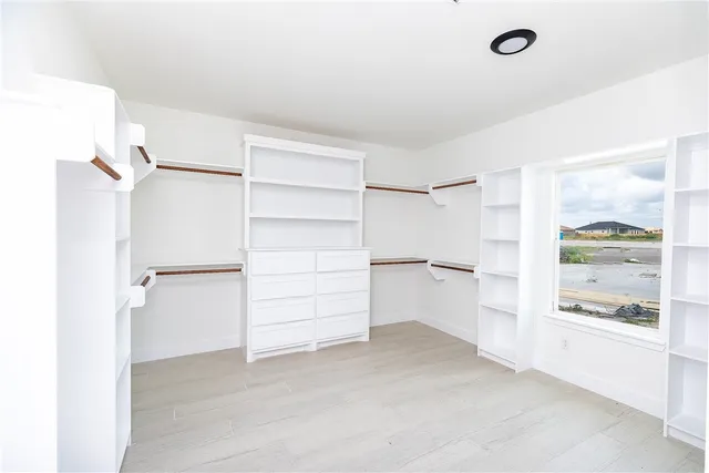 a view of walk in closet with empty racks