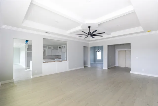 a view of an empty room with chandelier fan and fire place