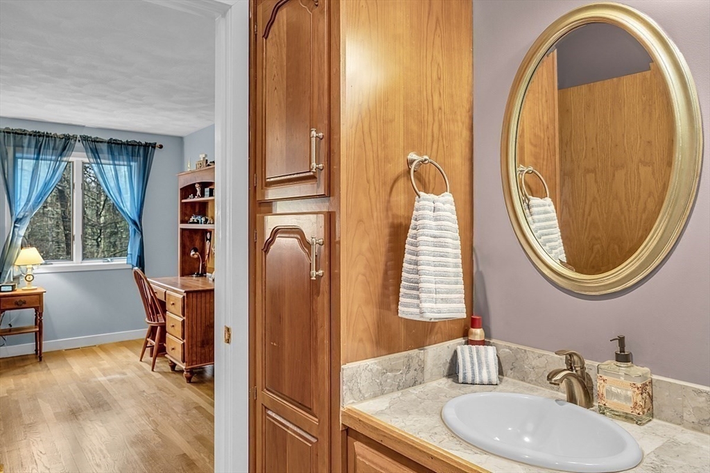 80 Elizabeth Ridge Road Carlisle, MA 01741 - Photo 23 of 33 a bathroom with a granite countertop toilet a sink and a mirror