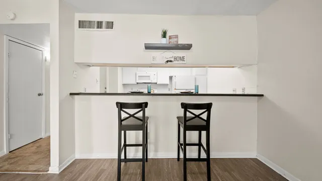 a kitchen with stainless steel appliances a dining table and chairs