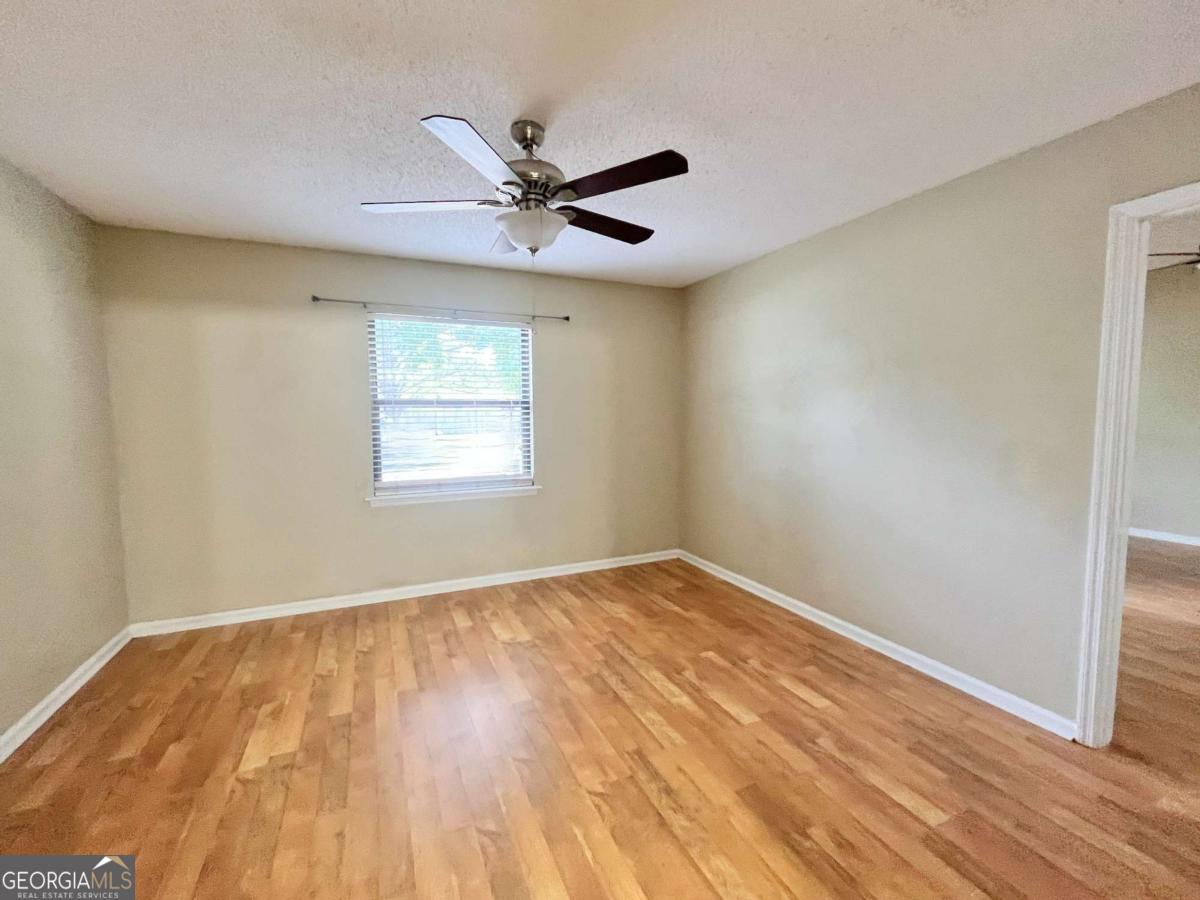 317 Lake View Drive Kingsland, GA 31548 - Photo 19 of 51 a view of an empty room with wooden floor and a window