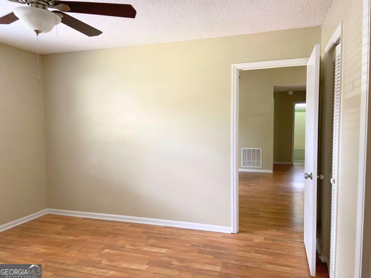 317 Lake View Drive Kingsland, GA 31548 - Photo 20 of 51 an empty room with wooden floor and windows