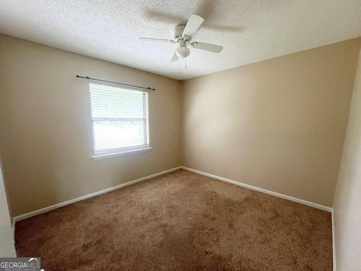 317 Lake View Drive Kingsland, GA 31548 - Photo 22 of 51 an empty room with a window and a fan
