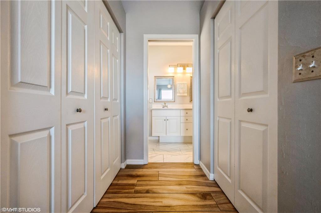 290 Robin Hood Circle, Unit 202 Naples, FL 34104 - Photo 26 of 38 a view of a hallway with wooden floor and a bathroom