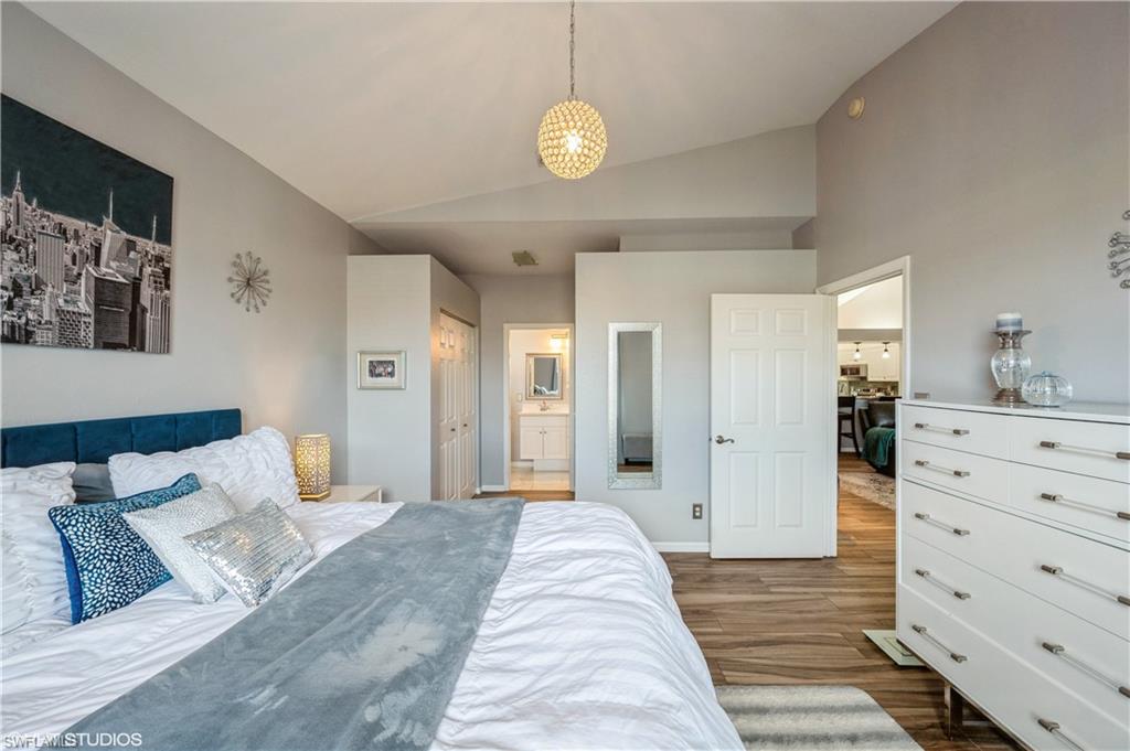 290 Robin Hood Circle, Unit 202 Naples, FL 34104 - Photo 31 of 38 a bedroom with a bed and cabinets