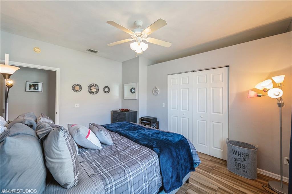 290 Robin Hood Circle, Unit 202 Naples, FL 34104 - Photo 33 of 38 a bedroom with a bed and a chandelier