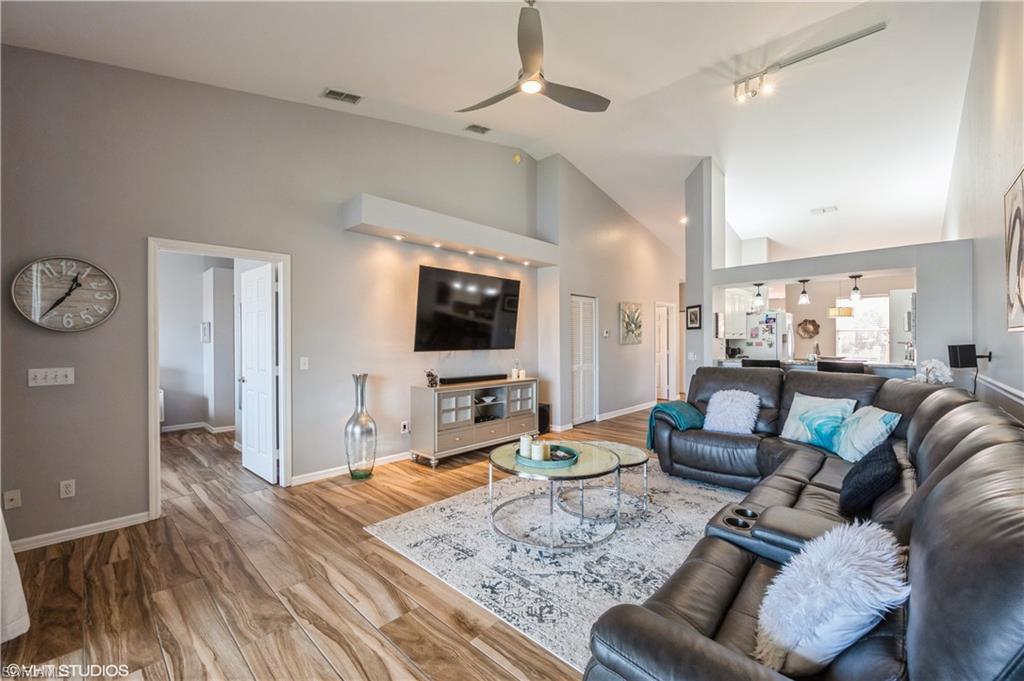 290 Robin Hood Circle, Unit 202 Naples, FL 34104 - Photo 7 of 38 a living room with furniture and a flat screen tv