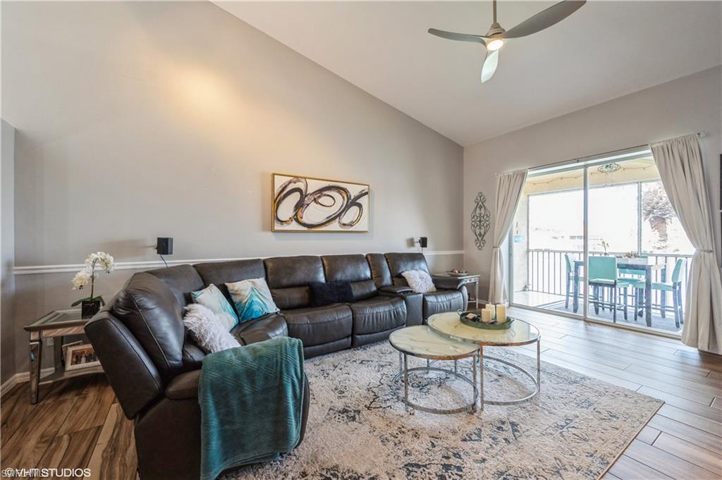 290 Robin Hood Circle, Unit 202 Naples, FL 34104 - Photo 9 of 38 a living room with furniture and a large window