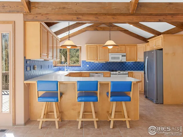 a kitchen with a dining table chairs and a refrigerator