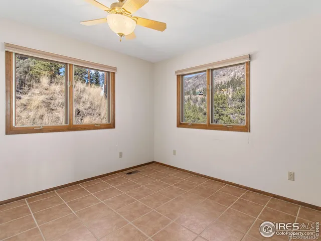 a view of an empty room with a window and a ceiling fan