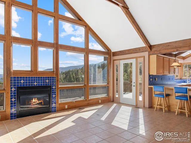 a living room with furniture a fireplace and a floor to ceiling window