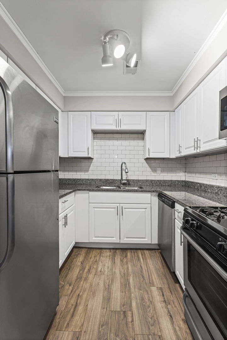 14457 Lamon Avenue, Unit 3N Midlothian, IL 60445 - Photo 11 of 21 a kitchen with granite countertop stainless steel appliances a stove top oven a sink and cabinets