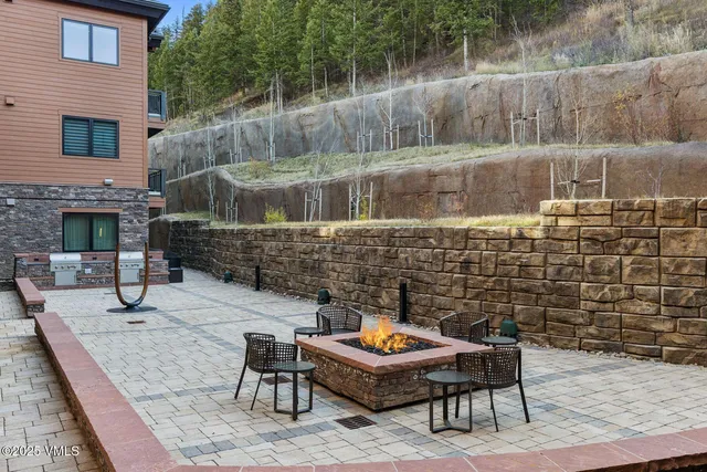 a backyard of a house with fountain table and chairs