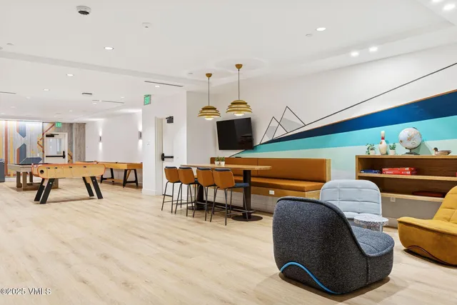 a living room with table tennis table and wooden floor