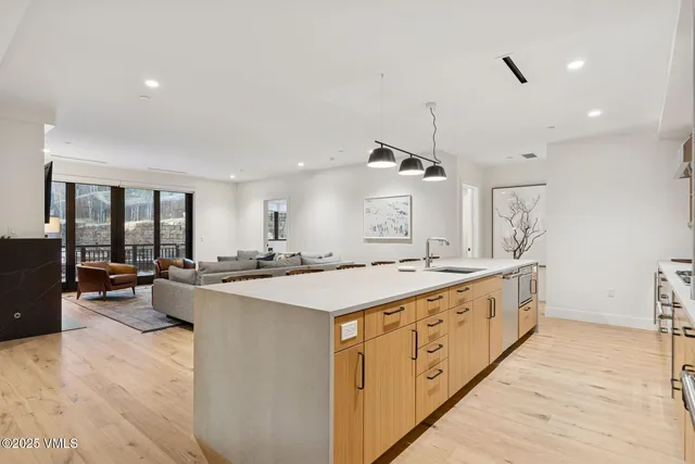 a large kitchen with kitchen island a stove a sink a center island and couches