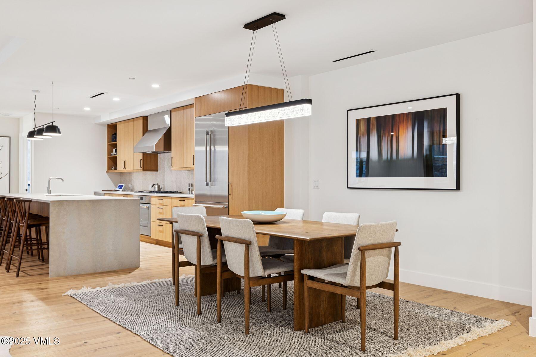 38460 Hwy 6 Avon Co 81620, Unit 205 Avon, CO 81620 - Photo 9 of 47 a dining hall with stainless steel appliances kitchen island granite countertop a table chairs and a refrigerator