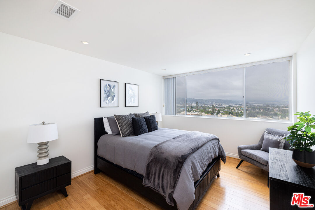 2220 Avenue Of The Stars, Unit 803 Los Angeles, CA 90067 - Photo 13 of 25 a spacious bedroom with a bed and a potted plant