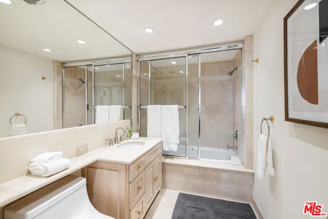 a bathroom with a tub sink a mirror and a shower